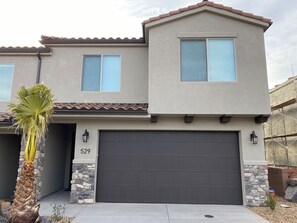 A two-story house with a dark garage door, stone accents, and a number '529' on the door. - Enjoyable townhome in gorgeous Washington with a great location (Washington)
