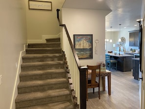 Escadaria que leva a uma sala de jantar com vista para a cozinha.