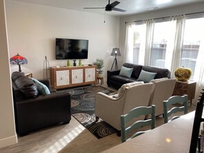 A living room with a sofa, chairs, a coffee table, a TV, and a decorative lamp. - Enjoyable townhome in gorgeous Washington with a great location (Washington)