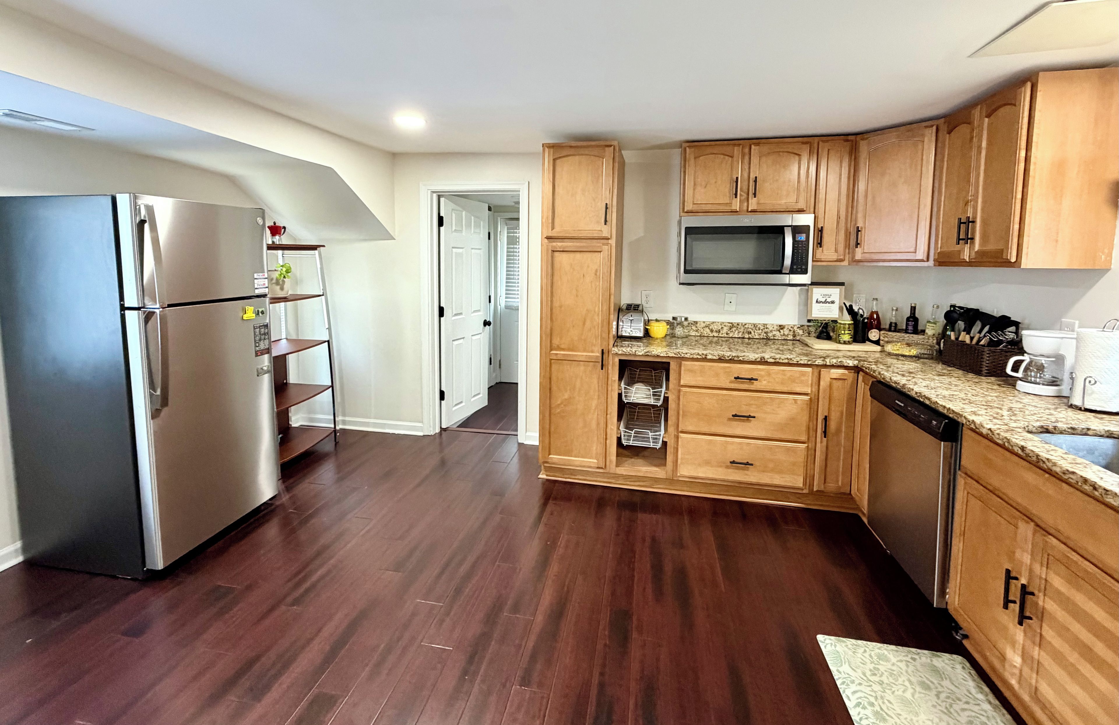 A modern kitchen with stainless steel appliances, wooden cabinets, and a granite countertop.