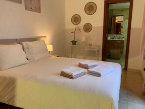 A hotel room with a bed, a bedside table with a lamp, and a mirror. - Relax, unwind and enjoy your own private villa in the Costa Papagayo area. (Playa Blanca)