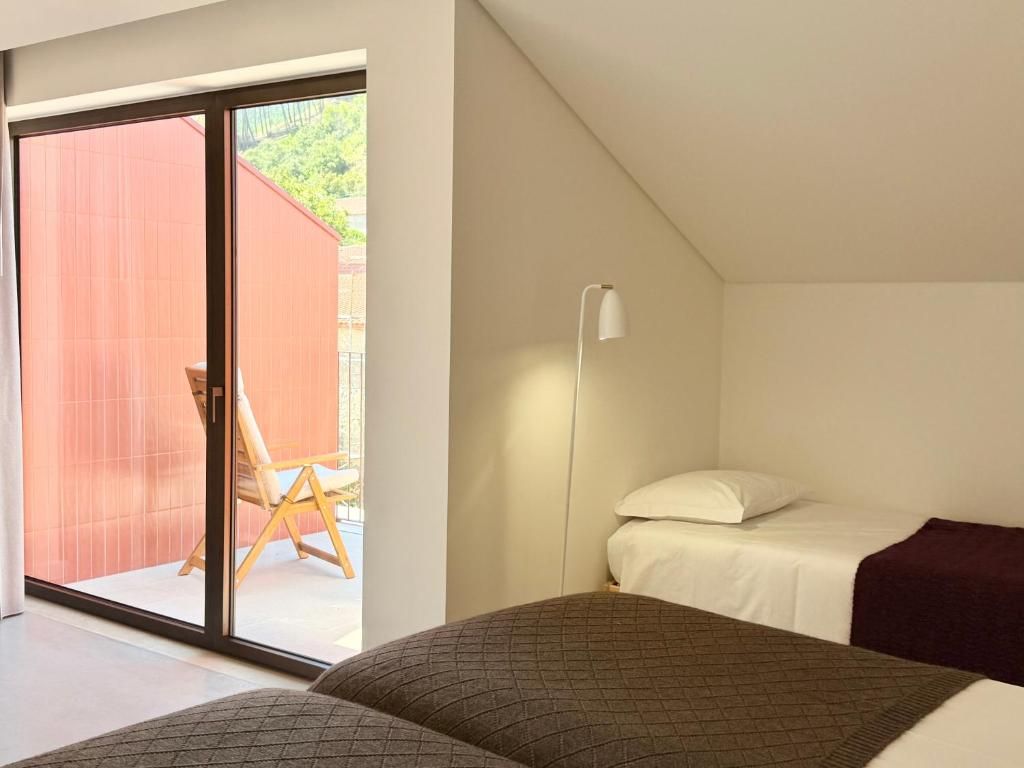 Une chambre à coucher comprenant un lit, une table de chevet, une lampe et une porte-fenêtre coulissante donnant sur un espace extérieur.