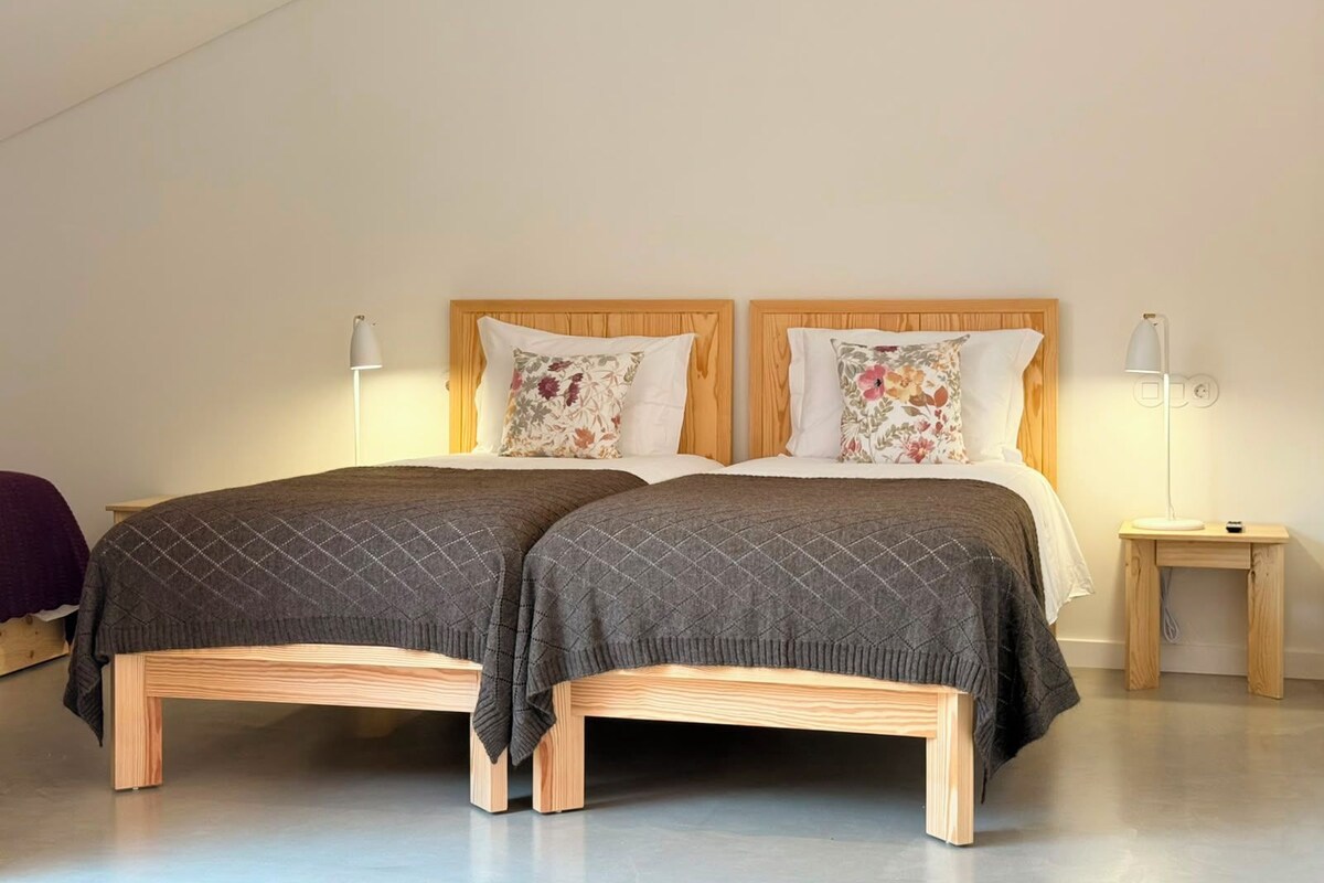 Ein Doppelbett mit Holz Kopfteil, zwei Nachttische und eine Stehlampe.