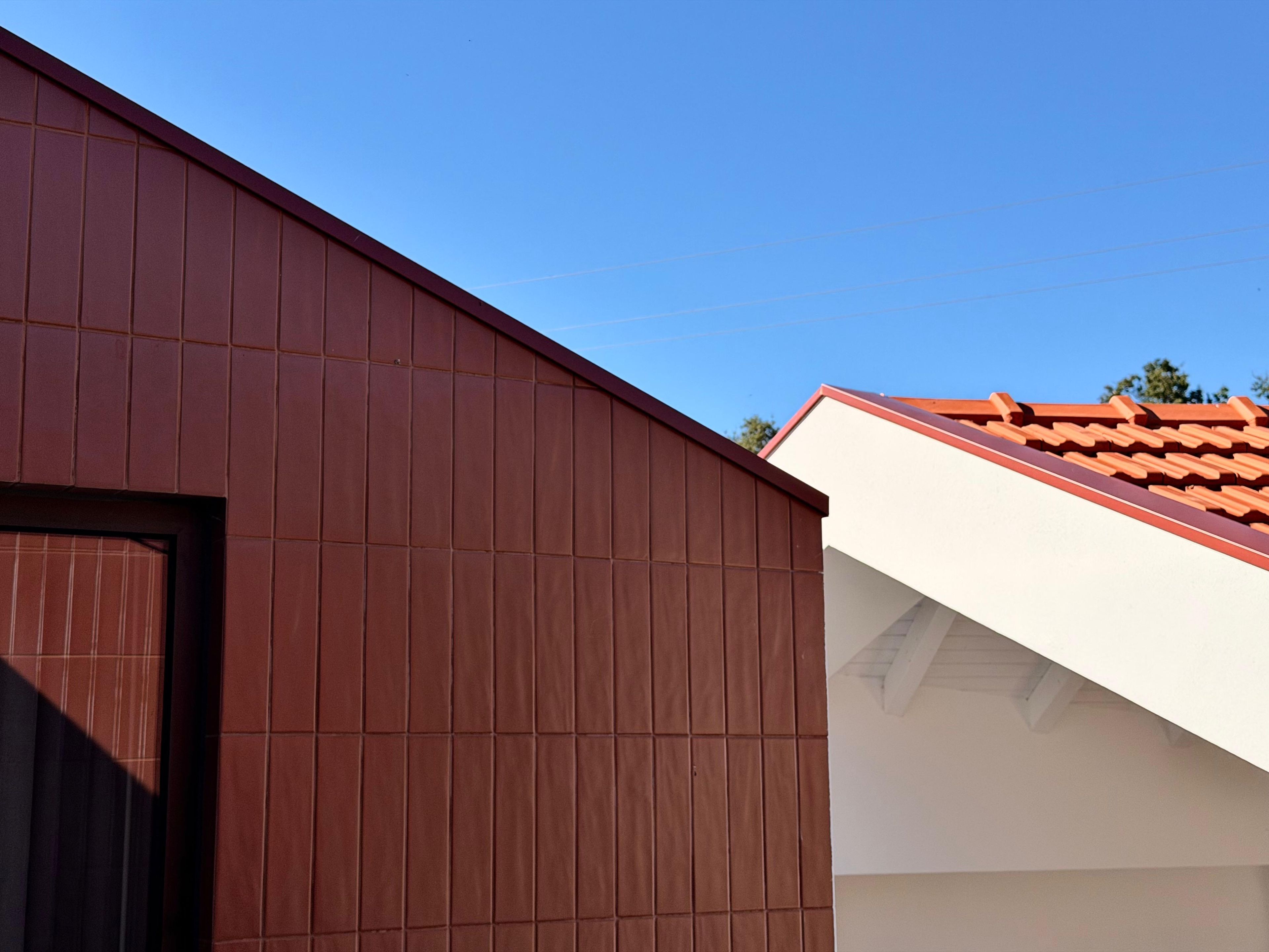Un bâtiment dont la façade est de couleur marron et le toit, blanc.