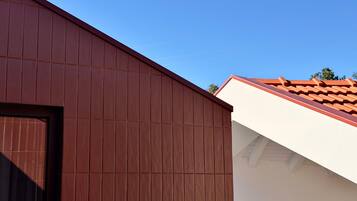 Un bâtiment dont la façade est de couleur marron et le toit, blanc.