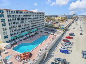Ein Hotel mit Schwimmbad, Strandzugang und Parkplatz.