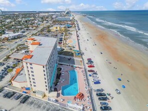 A hotel with a pool, beach access, and a parking lot. - Oceanfront Resort Condo - Beach + Pool Views (Daytona Beach)