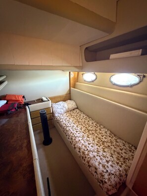 Habitación compacta con cama, una mesita y ventana con lámpara.