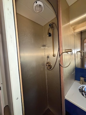 Une salle de bain avec une douche, un lavabo et un miroir.