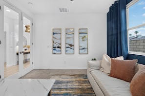 A modern living room with a sofa, a coffee table, and three framed artworks on the wall. - La Quinta Oasis w/Pool, Hot Tub, Outdoor Kitchen, 4bedrooms/4baths (La Quinta)