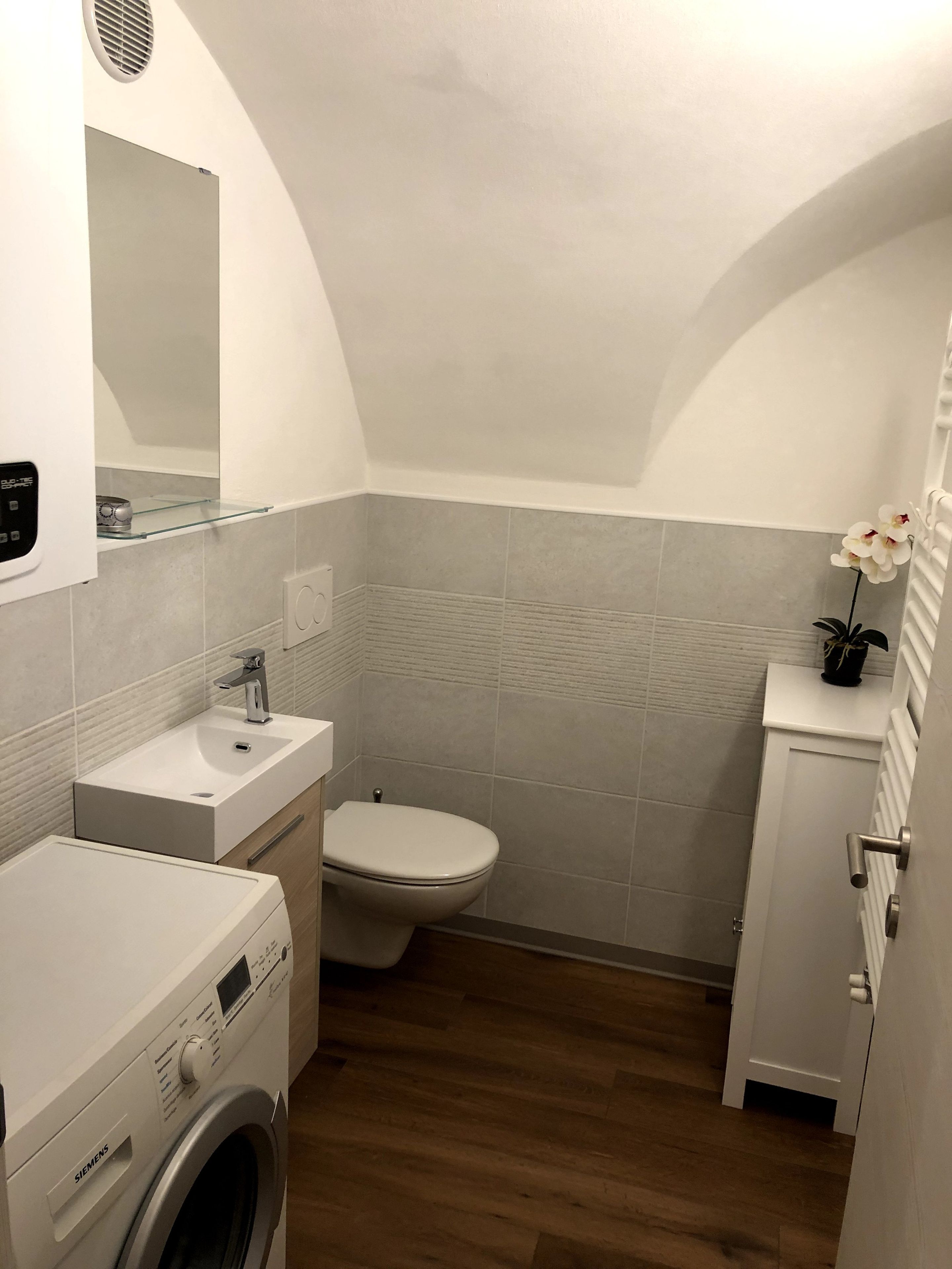 Un baño pequeño con lavadora, inodoro y lavabo.
