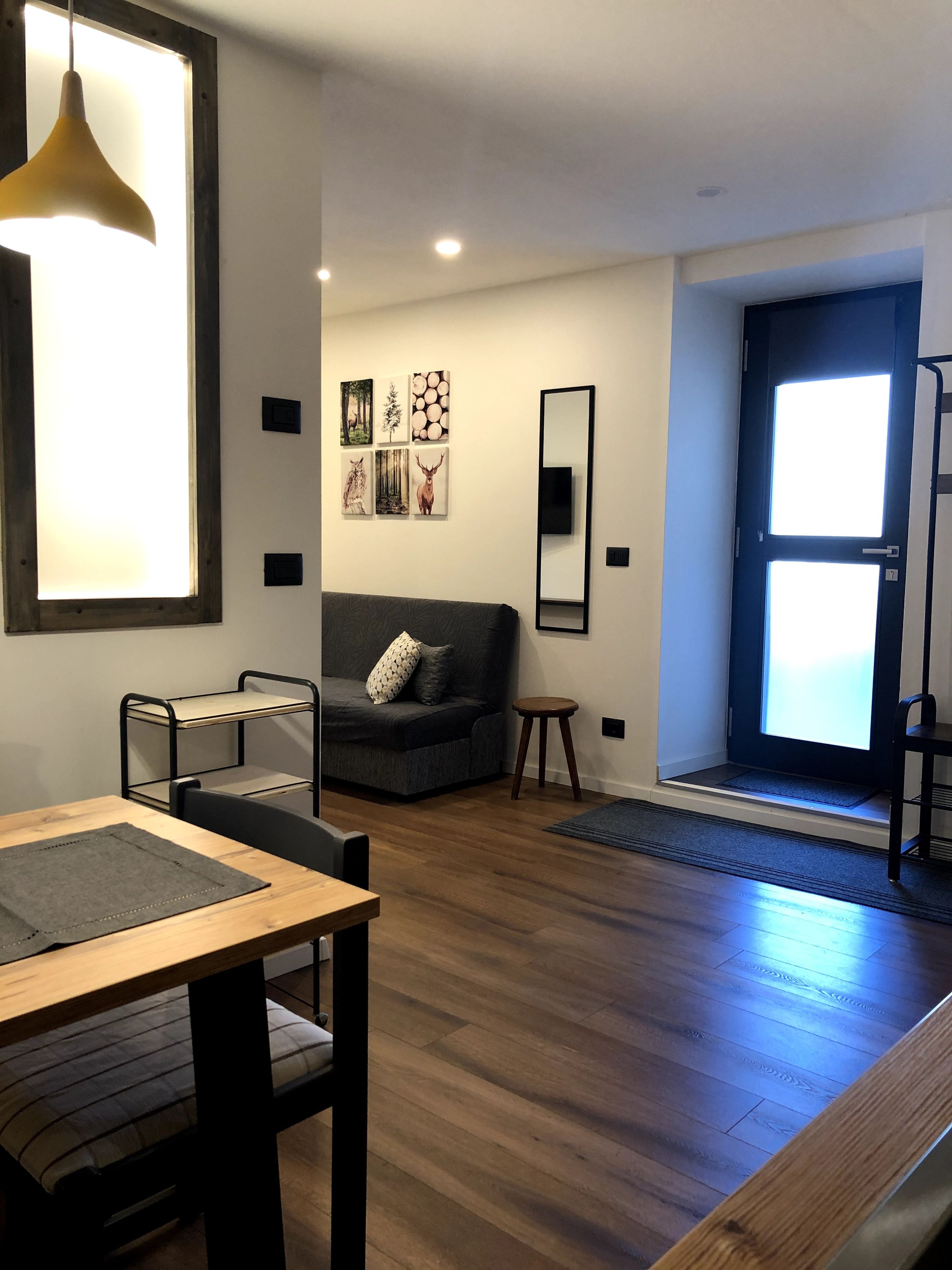 Ein modernes Wohnzimmer mit einer Couch, einem Esstisch, einer Bank und einem Fenster mit Blick.