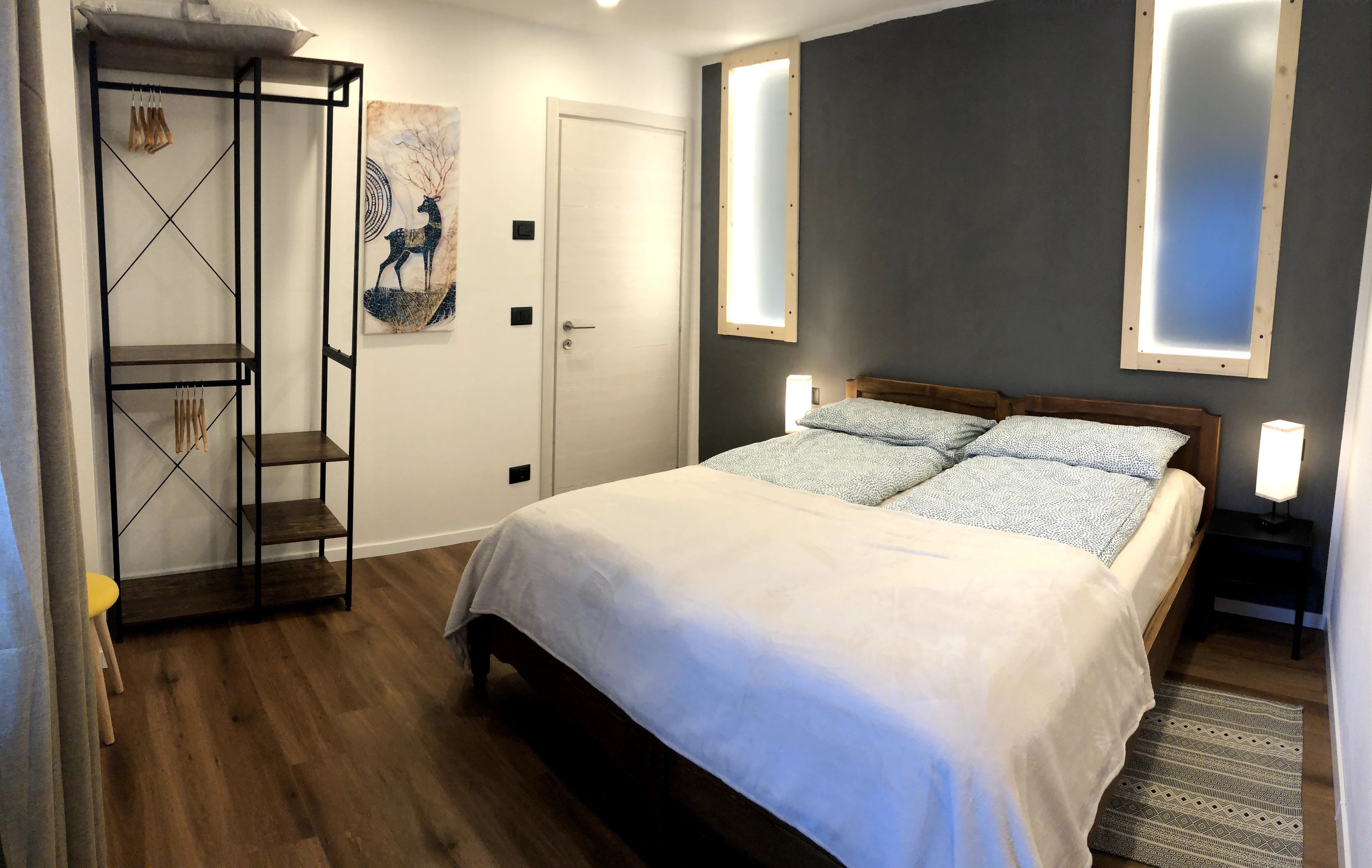 Un dormitorio con una cama, un armario y un cuadro en la pared.