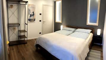 Un dormitorio con una cama, un armario y un cuadro en la pared.
