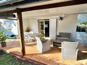 A covered patio area with outdoor furniture, including a table and chairs, and a sofa. - Fare Arava Huahine - 2-Bedroom Accommodation 50 Meters from the Beach (Fare)