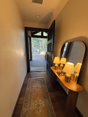 A hallway with a wooden floor, a rug, a bench with lamps, and a mirror. - Large Modern Mountain Lodge in Forest near Lake Mary - Sleeps 12 - Pets OK (Flagstaff)