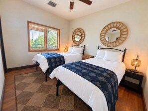 A hotel room with two beds, a large window with blinds, a ceiling fan, and two wall-mounted mirrors. - Large Modern Mountain Lodge in Forest near Lake Mary - Sleeps 12 - Pets OK (Flagstaff)