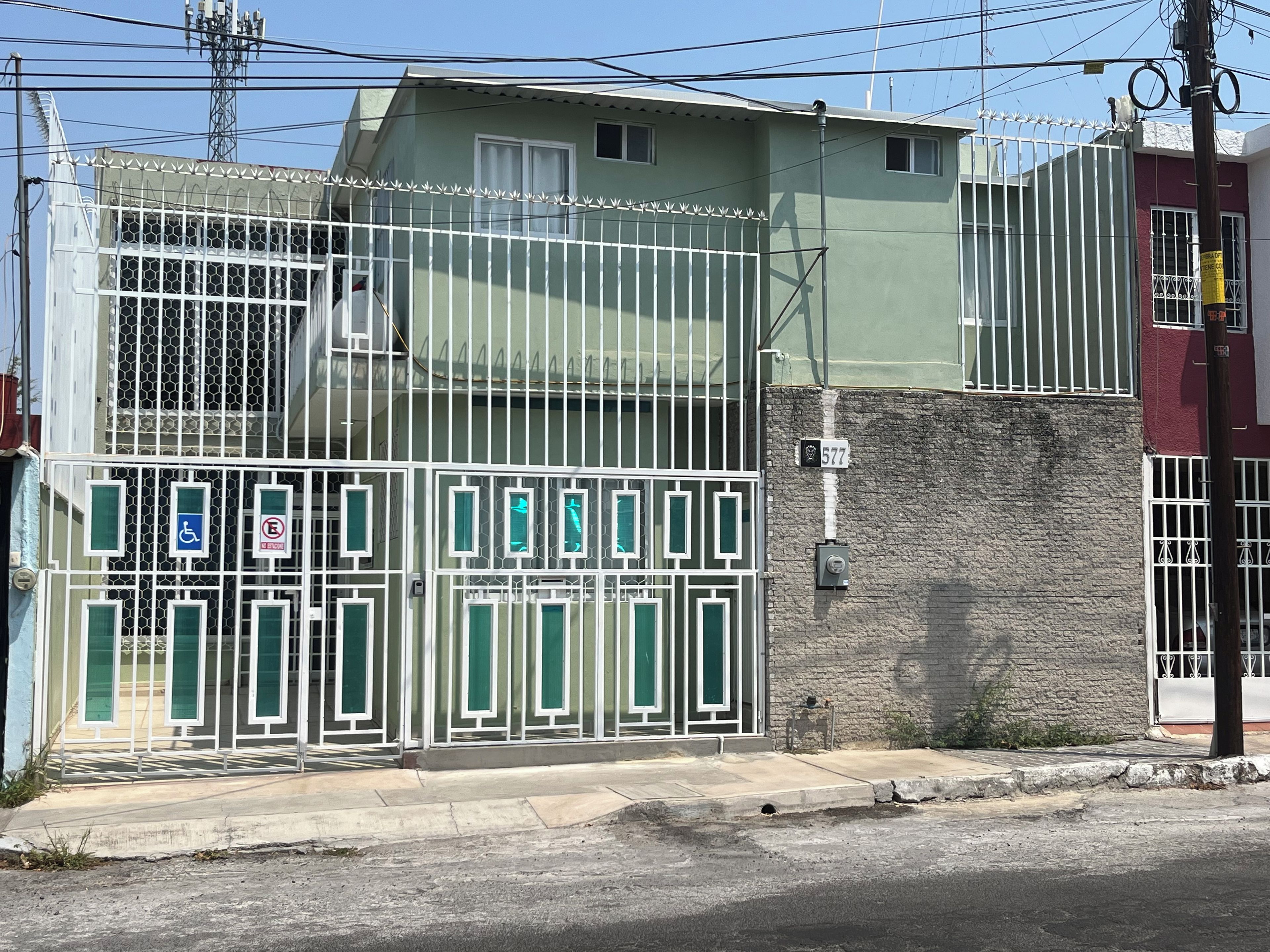 Une propriétéClose, délimitée par une clôture en métal, avec un panneau de signalisation et un poteau électrique.