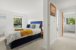Quarto com cama, mesa de cabeceira e janela.