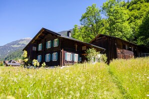 A wooden cabin with a sloped roof, multiple windows, and a chimney. - Penthouse Suite With Panoramic Views (Gaschurn)