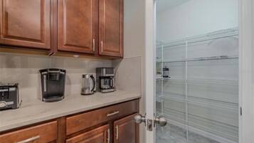 A kitchen with wooden cabinets, a countertop, and a coffee maker.