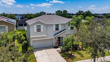 A residential house with a garage, a driveway, and a well-maintained lawn.