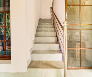 Una escalera con barandilla de metal y piso de madera.