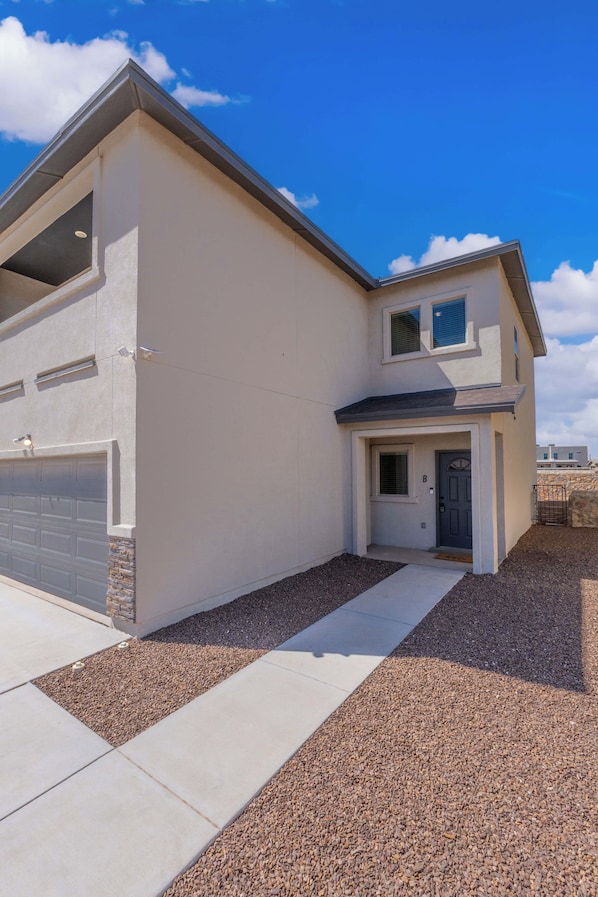 A modern two-story house with a garage, a front door, and a small porch area.