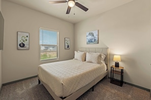 A bedroom with a bed, a ceiling fan, a window with blinds, and two wall-mounted pictures. - 3BR 2.5BA Modern Farmhouse • King Bed • Smart TVs A (El Paso)
