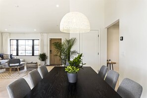 A modern dining area with a dark wooden table, grey upholstered chairs, and a large woven pendant light. - Reesor: Scottsdale Home with Private Pool & Spa (Scottsdale)