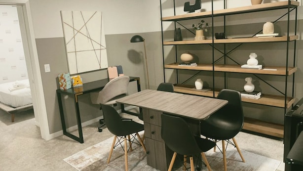 A room with a desk, chairs, a bookshelf, and a bed. - Modern New 2BR beside Park, 14m WEM, 4m Grocery (Edmonton)