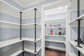 A kitchen with white shelves and black metal supports.