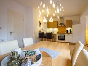 Eine moderne Küche mit Holzausbau, einem eingebauten Backofen und einer Pendelleuchte.
