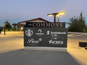 Ein Schild mit Logos verschiedener Unternehmen, darunter Starbucks, Cascadia Liquor, Scotiabank, Pure Pharmacy und Aceria Insurance.