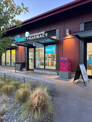 Een apotheek met een bord waarop 'Integrative Apotheek' staat en een brievenbus voor Canada Post.