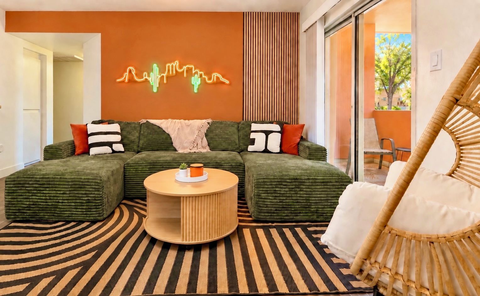 A modern living room with a sectional sofa, a round coffee table, and a rattan chair.