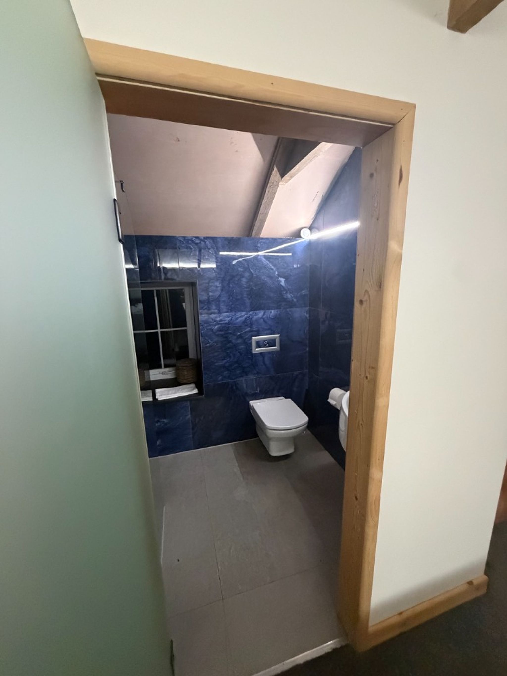 A small bathroom with a toilet, a sink, and a shower area.
