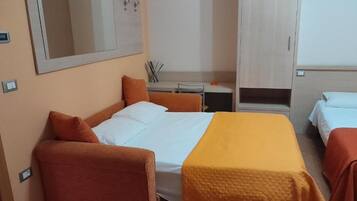 A hotel room with a bed, a desk, and a wardrobe.