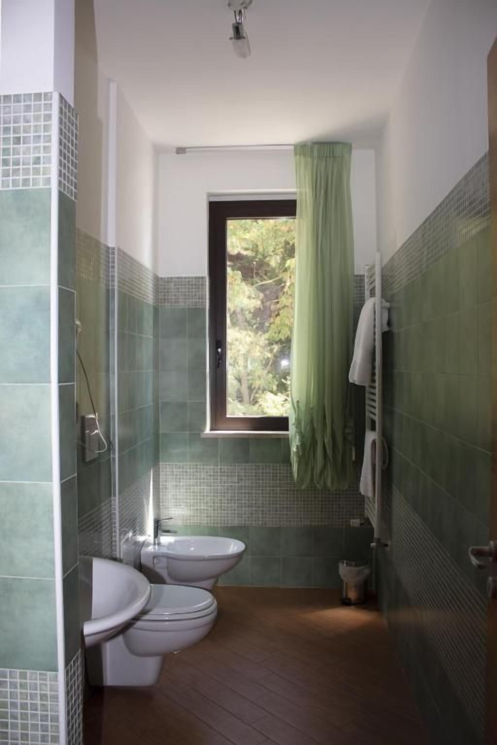 A bathroom with a shower, toilet, and bidet.
