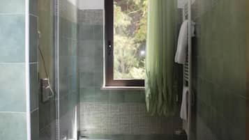 A bathroom with a shower, toilet, and bidet.