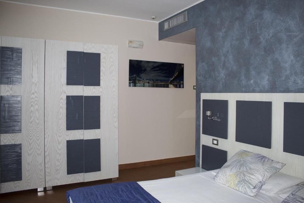 Ein Schlafzimmer mit einem Bett, einem Kleiderschrank und einem Bild an der Wand.