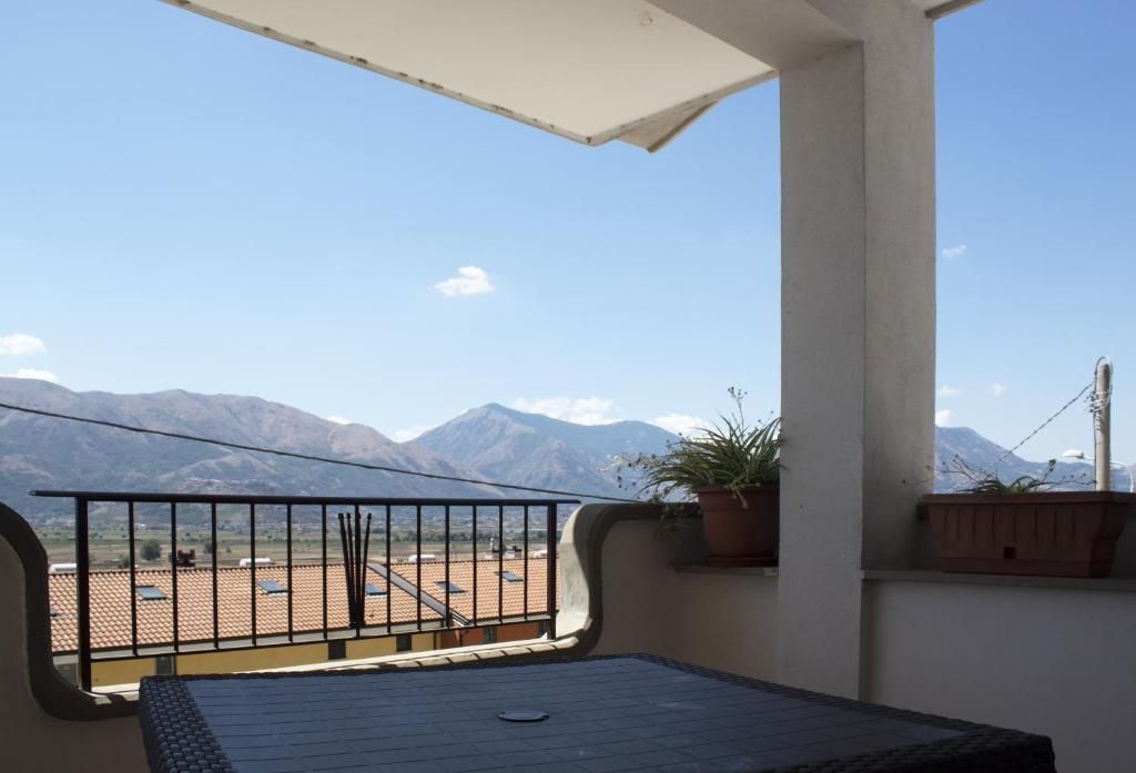 Ein Balkon mit Bergblick, Fliesenboden und einem Blumentopf.