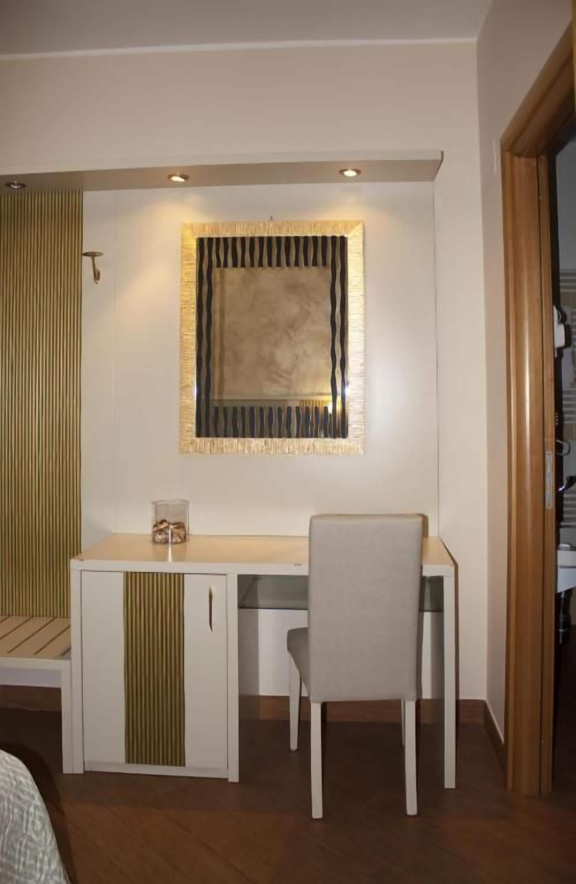 Un petit bureau privé, équipé d’un bureau, d’une chaise et d’un élément décoratif mural.