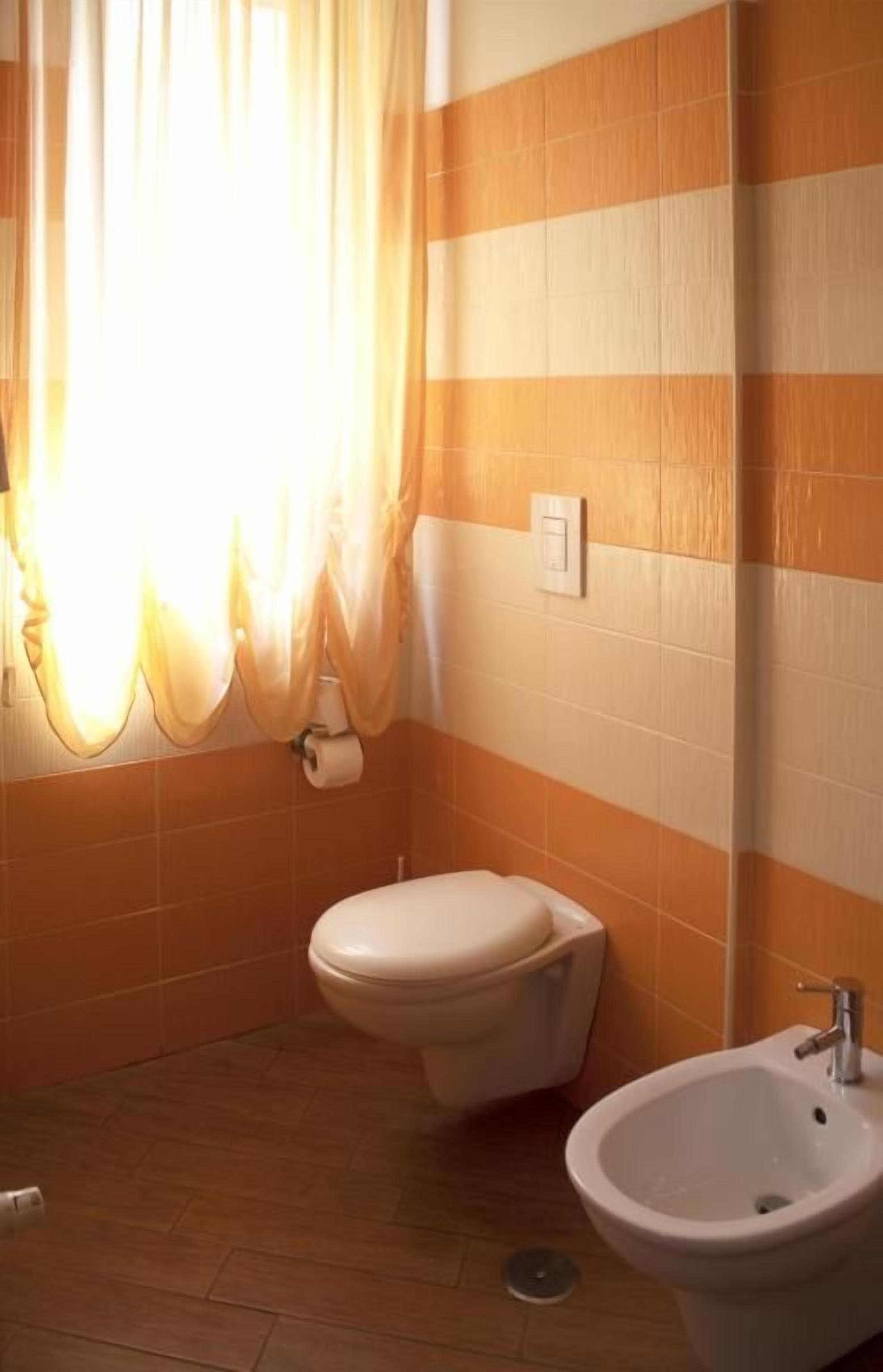 Een badkamer met toilet, wastafel en douchegordijn.