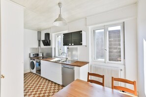 Cocina compacta con microondas, lavavajillas y pileta.