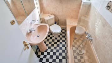 Un baño con lavamanos, inodoro y bañera.