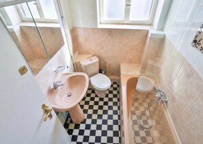Un bagno con lavandino, wc e vasca.