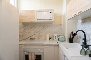 A modern kitchen with a microwave, oven, and sink. - Kalimera - Jacuzzi & Sauna (Oullins-Pierre-Bénite)