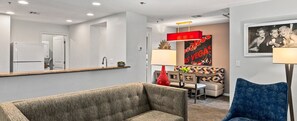 A modern living room with a sofa, a dining area with a bench, and a kitchen area with a refrigerator. - Wyndham Tropicana 2 bdrm in Las Vegas for F1 weekend w/ outdoor pool and hot tub (Las Vegas)