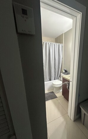 A bathroom with a toilet, a shower curtain, and a sink. - 2 bedroom house , one bedroom
Available small dog on property plenty of parking (Hollywood)